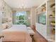 Bedroom with large window, chandelier, decorative shelving, and hardwood floors at 1172 Queens Rd, Charlotte, NC 28207