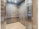 An interior view of the elevator with wood floors and silver walls at 1172 Queens Rd, Charlotte, NC 28207