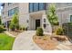 Charming front entrance with a stone pathway, manicured landscaping, and a black front door at 1172 Queens Rd, Charlotte, NC 28207