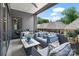 A comfortable covered patio features cozy seating, a ceiling fan, and views of the backyard at 1172 Queens Rd, Charlotte, NC 28207