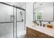 Modern bathroom with white marble tiling, glass shower, and wood-finish vanity with stone countertop at 12013 Dolomite Dr, Pineville, NC 28134