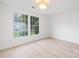 Bright bedroom with hardwood floors, two windows providing ample natural light, and a modern ceiling light at 12013 Dolomite Dr, Pineville, NC 28134
