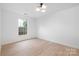 Bright bedroom featuring neutral paint, hardwood floors, a modern ceiling light, and a large window at 12013 Dolomite Dr, Pineville, NC 28134