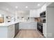 Modern kitchen with stainless steel appliances, white cabinets and countertops, and light wood floors at 12013 Dolomite Dr, Pineville, NC 28134