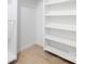 Bright walk-in closet featuring custom white shelving, rod, and blonde wood floor at 12013 Dolomite Dr, Pineville, NC 28134