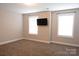 Bright bedroom with neutral walls, carpet, and a wall-mounted television at 12150 Plover Dr, Charlotte, NC 28269