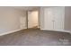 Bedroom with carpet, neutral walls, white doors and a double closet at 12150 Plover Dr, Charlotte, NC 28269