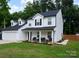 Well-maintained two-story home with a covered front porch, attached garage and manicured lawn at 12150 Plover Dr, Charlotte, NC 28269