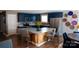 Stylish kitchen featuring blue cabinets, granite countertops, and a herringbone-patterned island with seating at 12150 Plover Dr, Charlotte, NC 28269