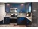 Well-equipped kitchen with blue cabinets, gray backsplash, and stainless steel appliances at 12150 Plover Dr, Charlotte, NC 28269