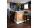 Close-up of kitchen island with herringbone wood detail, granite countertops and bar stools at 12150 Plover Dr, Charlotte, NC 28269