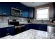 Navy kitchen boasting granite countertops, stainless steel appliances, and herringbone backsplash at 12150 Plover Dr, Charlotte, NC 28269