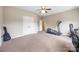Carpeted bedroom space with double doors, an elliptical machine, and desk area at 12312 Mcallister Park Dr, Charlotte, NC 28277