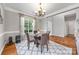 Cozy dining room featuring a glass-top table, elegant chandelier, and large window with natural light at 12312 Mcallister Park Dr, Charlotte, NC 28277