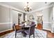 Comfortable dining room featuring a glass-top table, elegant chandelier, and hardwood floors at 12312 Mcallister Park Dr, Charlotte, NC 28277