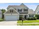 Charming two-story home featuring a well-manicured lawn, attached garage, and inviting front porch at 12312 Mcallister Park Dr, Charlotte, NC 28277