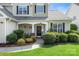 Inviting front porch with decorative wreath, manicured landscaping, and a well-maintained lawn at 12312 Mcallister Park Dr, Charlotte, NC 28277