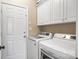 Bright laundry room with white cabinets and modern washer and dryer units at 12312 Mcallister Park Dr, Charlotte, NC 28277