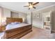 Spacious main bedroom featuring a wooden bed frame, ceiling fan, and adjoining bathroom at 12312 Mcallister Park Dr, Charlotte, NC 28277