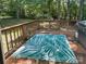 View of the cozy outdoor wooden deck showcasing a green and white patterned rug at 125 Shenandoah Loop, Troutman, NC 28166