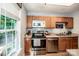 Bright kitchen featuring stainless steel appliances, wood cabinets, and natural light from a window at 125 Shenandoah Loop, Troutman, NC 28166
