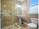 Bathroom with glass shower, tiled walls and floor, pedestal sink, and natural light from a window at 129 N Audubon Ave, Mooresville, NC 28117