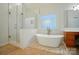 Bathroom featuring freestanding tub, glass shower, and decorative tile floor creating a spa-like retreat at 129 N Audubon Ave, Mooresville, NC 28117