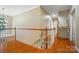 Hallway with a hardwood floor and staircase with white posts and a wooden handrail at 129 N Audubon Ave, Mooresville, NC 28117