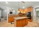 Modern kitchen featuring stainless steel appliances, a center island, and open layout to the living spaces at 129 N Audubon Ave, Mooresville, NC 28117