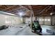 Unfinished basement with exposed ceiling joists, a garage door, and lawn equipment at 139 Cricket Creek Dr, Cherryville, NC 28021