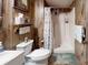 Rustic bathroom with wood paneling features a stand up shower and toilet at 139 Cricket Creek Dr, Cherryville, NC 28021