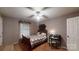 Cozy bedroom featuring a vintage wooden bed frame, a desk, a ceiling fan, and patterned wallpaper at 139 Cricket Creek Dr, Cherryville, NC 28021
