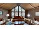 An impressive living room, featuring tall ceilings, a wall of windows, and a leather sofa at 139 Cricket Creek Dr, Cherryville, NC 28021