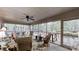 Enclosed sunroom featuring views of wooded backyard, ceiling fan, and comfortable furniture at 139 Cricket Creek Dr, Cherryville, NC 28021