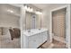 Well-lit bathroom featuring a double sink vanity with large mirror and a shower with a patterned curtain at 14734 Rivergate Pkwy, Charlotte, NC 28273