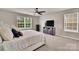 Bedroom with large window, ceiling fan, and closet with view from bed to mounted television at 14734 Rivergate Pkwy, Charlotte, NC 28273
