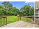 Spacious backyard featuring a wooden deck, green lawn, and mature trees at 1543 Newfound Hollow Dr, Charlotte, NC 28214