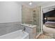 Bathroom featuring a tiled walk-in shower, tub and window into main bedroom at 1543 Newfound Hollow Dr, Charlotte, NC 28214