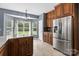 Well-lit kitchen with stainless steel fridge, granite countertops, island and tile flooring at 1543 Newfound Hollow Dr, Charlotte, NC 28214