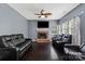 Spacious living room with a fireplace, ceiling fan, and plush leather seating at 1543 Newfound Hollow Dr, Charlotte, NC 28214