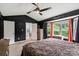 Comfortable main bedroom featuring a ceiling fan, black accent wall and window with natural light at 1543 Newfound Hollow Dr, Charlotte, NC 28214