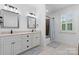 Well-lit bathroom featuring double sinks with white cabinets, decorative mirrors and shuttered window at 175 Mcleod Ave, Belmont, NC 28012