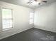 Spacious bedroom featuring carpet flooring, a ceiling fan, and natural light from two windows at 1911 Flushing Ct, Charlotte, NC 28215