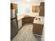 Functional kitchen with stainless steel refrigerator and wooden cabinets above and below laminate countertops at 1911 Flushing Ct, Charlotte, NC 28215