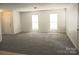Spacious living room with gray carpets, bathed in natural light from large windows, creating a warm and welcoming ambiance at 1911 Flushing Ct, Charlotte, NC 28215
