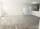Bright living room showcasing plush gray carpeting, and large windows for natural light at 1911 Flushing Ct, Charlotte, NC 28215