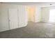 Large living room with plush gray carpets and multiple entry doors offering easy access to other areas at 1911 Flushing Ct, Charlotte, NC 28215