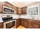 Well-lit kitchen features stainless steel appliances, granite countertops, and dark wood cabinetry at 201 S 5Th Ave, Maiden, NC 28650