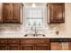 Granite countertops and subway tile backsplash highlight a stainless sink in this kitchen at 201 S 5Th Ave, Maiden, NC 28650
