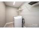 Bright laundry room features gray walls, tile floors, wire shelving, and a modern washing machine at 201 S 5Th Ave, Maiden, NC 28650